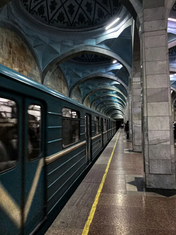 a train traveling through a train station next to a platform